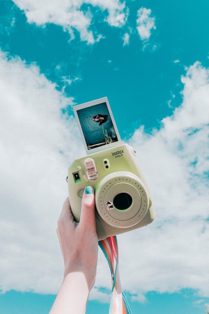 Person Holding Instant Camera With Photo